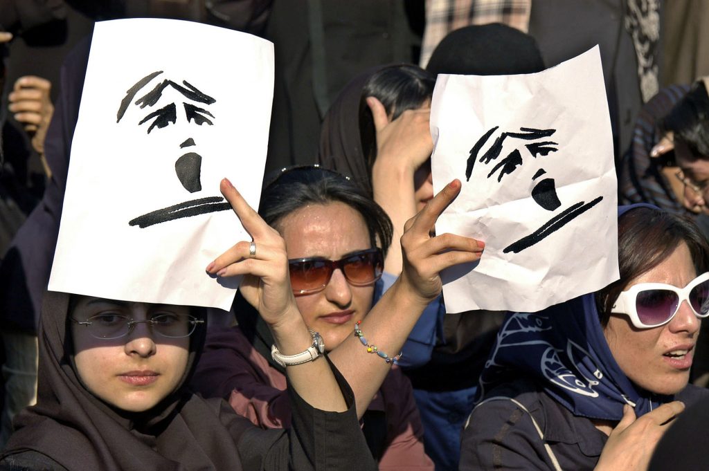 Iranian women hold banners during an Iranian Women Movement rally in front of Tehran University Sunday June 12, 2005. About 300 women took part in the protest against gender discrimination in the Islamic Republic. Image via AP.